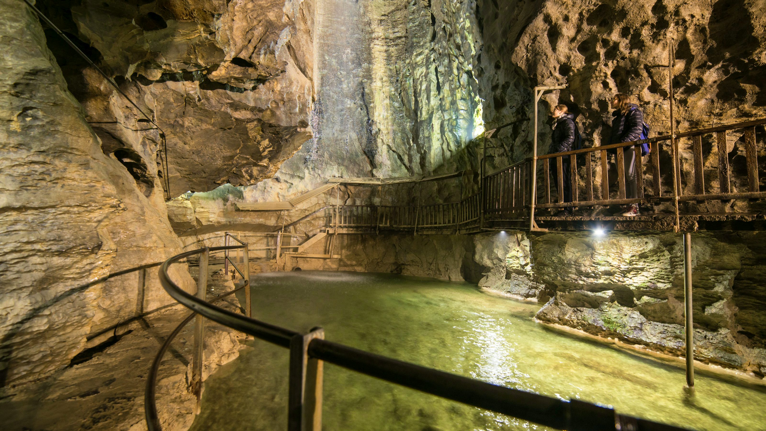 Depuis la passerelle qui longe une paroi rocheuse à gauche de la grotte, on aperçoit sur la droite un lac aux eaux limpides et aux reflets dorés. Deux amas rocheux le surplombent à gauche et à droite et laissent apparaître plus loin une large et haute salle. Des spots éclairent cette grotte. Une autre passerelle longe également la paroi de droite. L’ambiance est mystérieuse.
