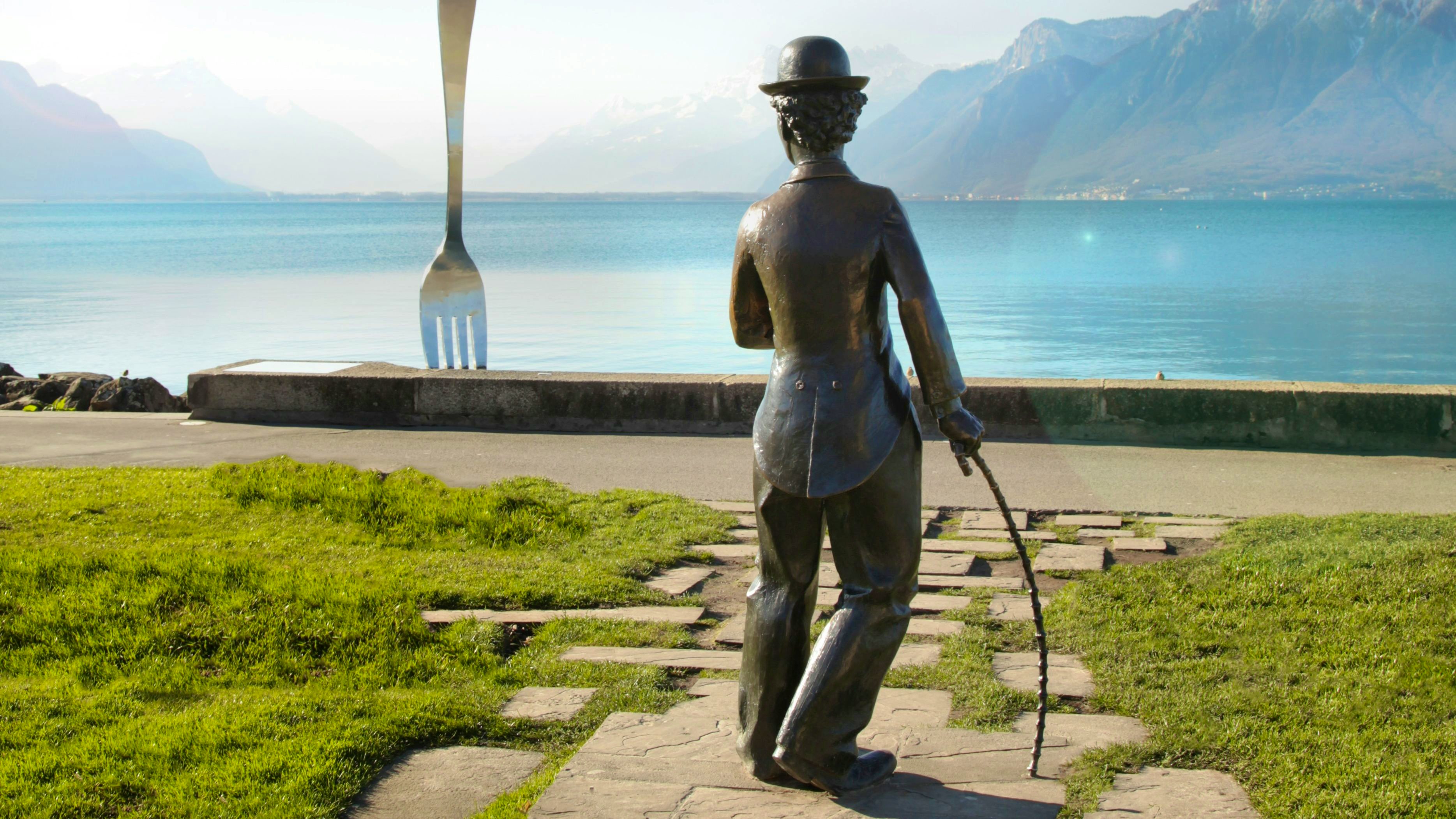 A fork stuck into the lake and the back of the Chaplin statue can be seen from the promenade.