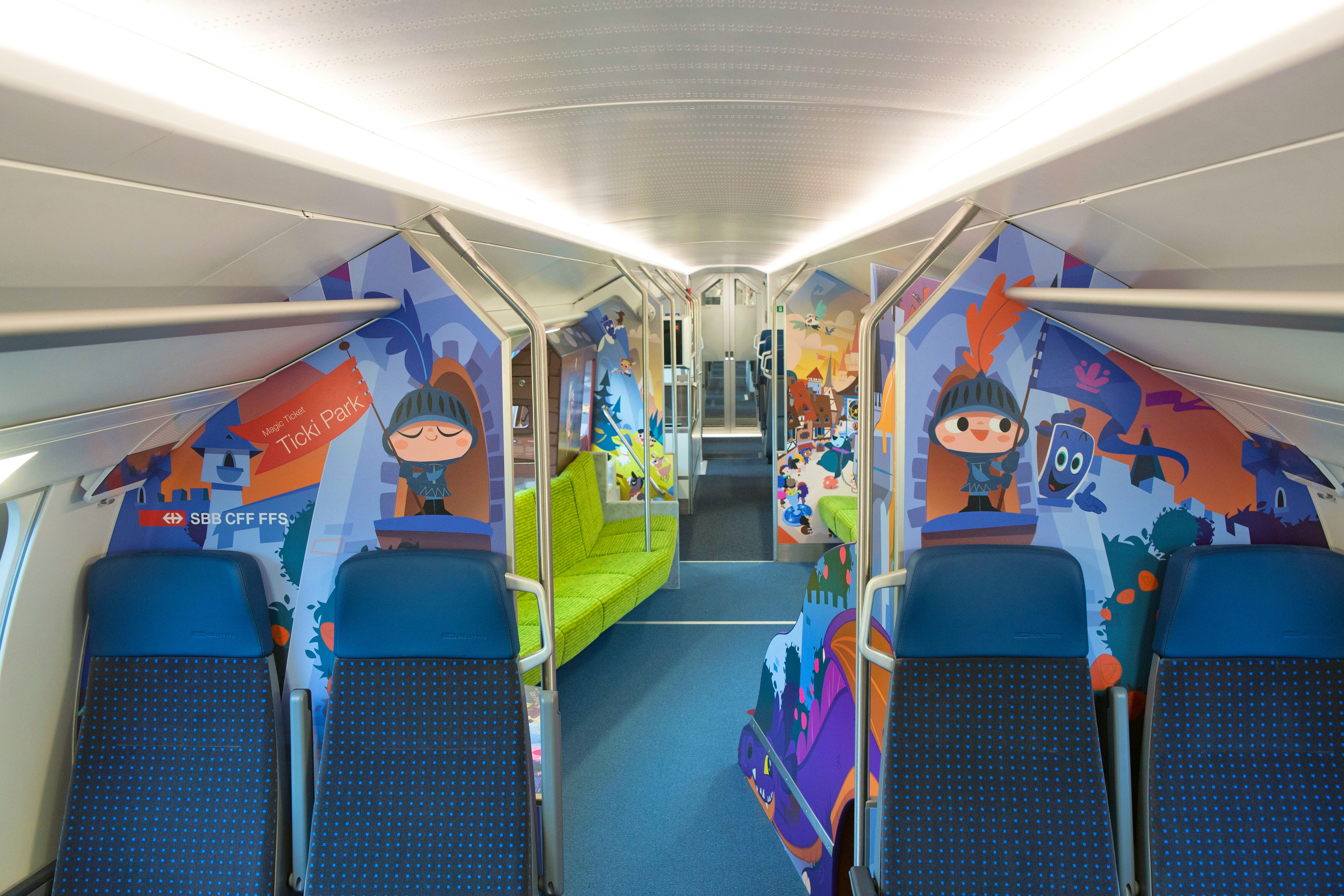 Carrozza famiglia sull’IC 200 – Prima della zona dedicata ai bambini sono disponibili posti a sedere da entrami i lati del corridoio. Nella zona di gioco si nota una fila di sedili verdi sulla sinistra.