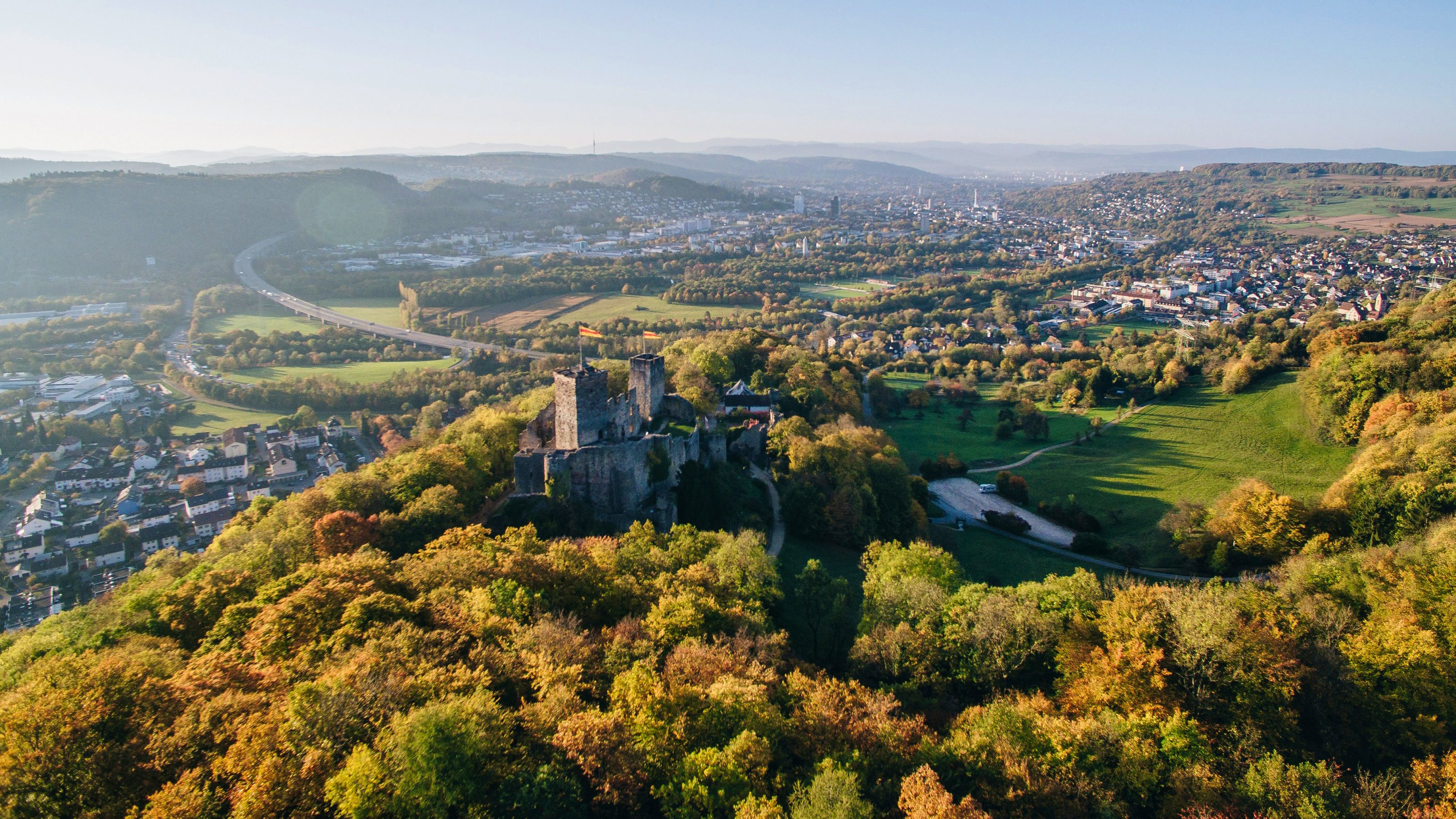 Burgruine auf Hügel mit Aussicht auf die Stadt Lörrach und Basel.